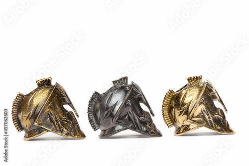 Gold, bronze and metal Spartan helmet on a white background