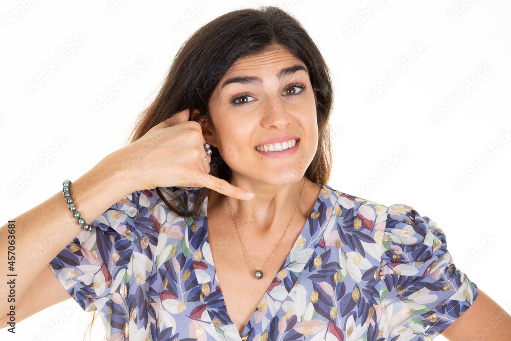 Woman brunette make phone gesture call me back with hand and fingers like talking on phone cell isolated on white background Woman brunette make phone gesture call me back with hand and fingers like talking on phone cell isolated on white background