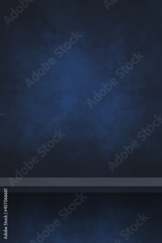 Empty shelf on a black and blue concrete wall. Background template. Vertical backdrop