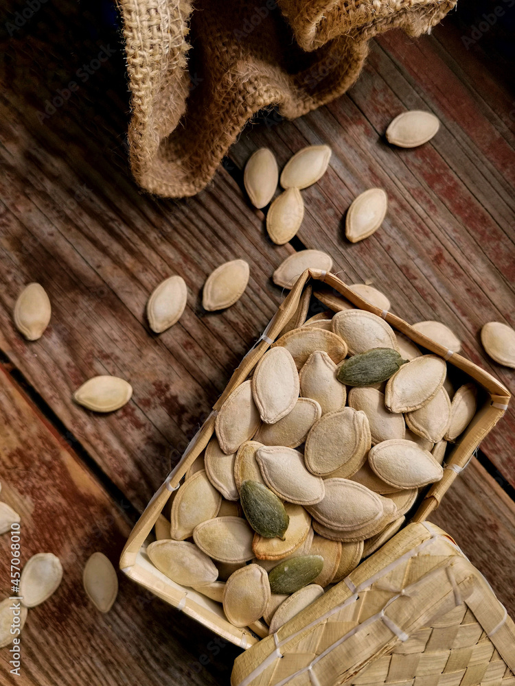 Pumpkin seeds in a box on a wooden table Pumpkin seeds in a box on a wooden table