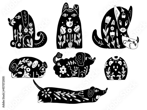Set of black silhouettes of stylized dogs with folk patterns and natural decorations. Vector black prints of various puppys with a tribal boho pattern. photo