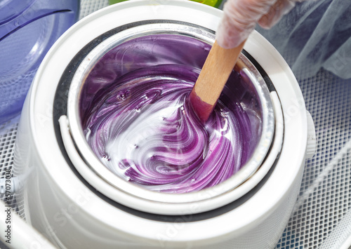 Shot of melted purple wax on wooden stick for depilation photo