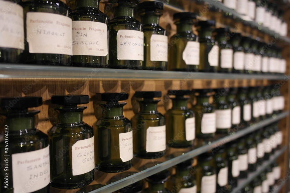 Opaque glass ingredient bottles (vial, flacon,containers) on shelves with essence extract substances, mix making french aroma perfumery.  Fragonard Museum, Paris inspiration history of  manufacturing - obrazy, fototapety, plakaty 