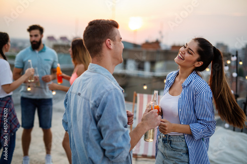 Photography Friends having fun and drinking cocktails outdoor on a rooftop party get together