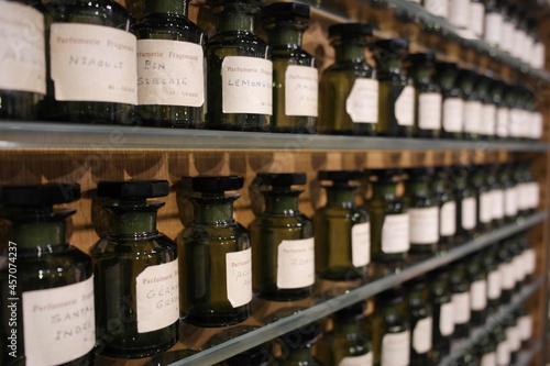 Canvas Print Opaque glass ingredient bottles (vial, flacon,containers) on shelves with essence extract substances, mix making french aroma perfumery