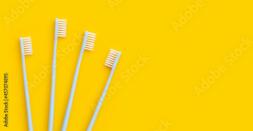Toothbrushes on yellow background. Top view