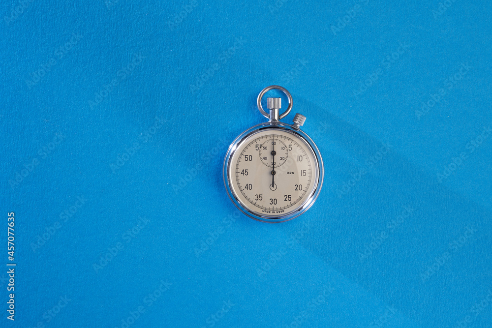 silver stopwatch on blue background silver stopwatch on blue background