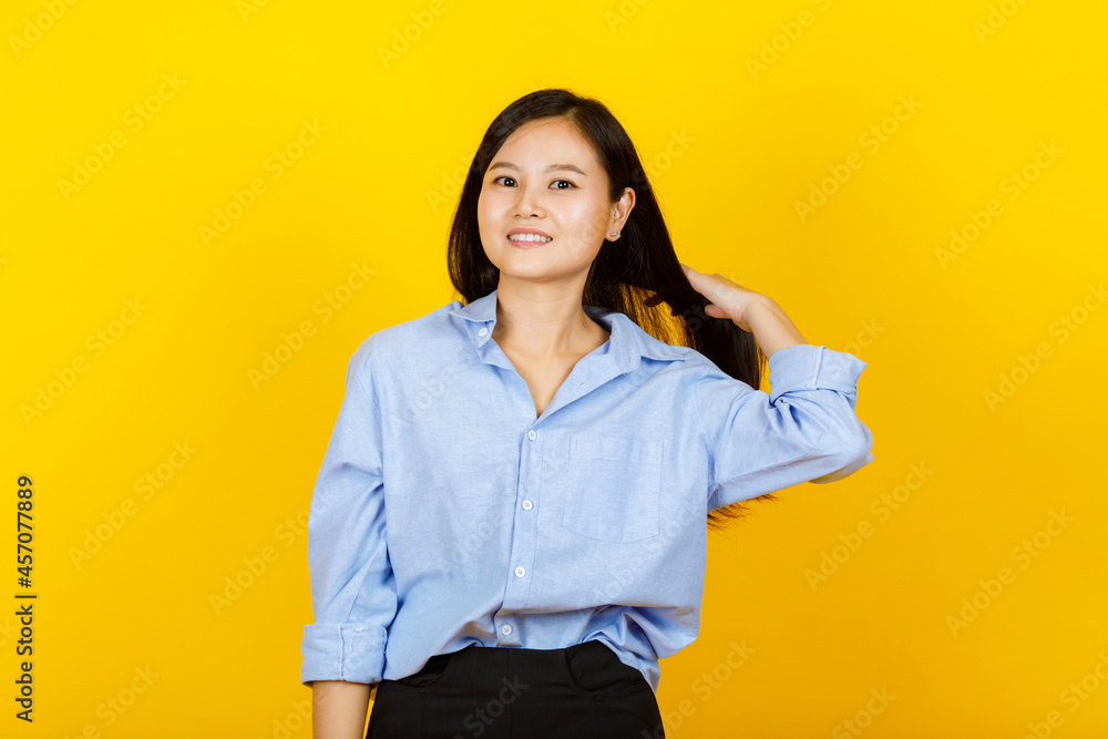 Portrait of young and cute Chinese, Japanese style woman pose to camera with positive gesture and friendly smile on yellow camera Portrait of young and cute Chinese, Japanese style woman pose to camera with positive gesture and friendly smile on yellow camera