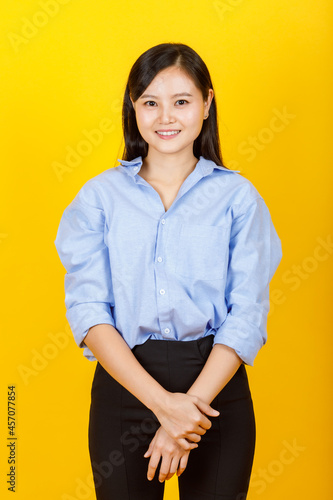 Portrait of young and cute Chinese, Japanese style  woman pose to camera with positive gesture and friendly smile on yellow camera