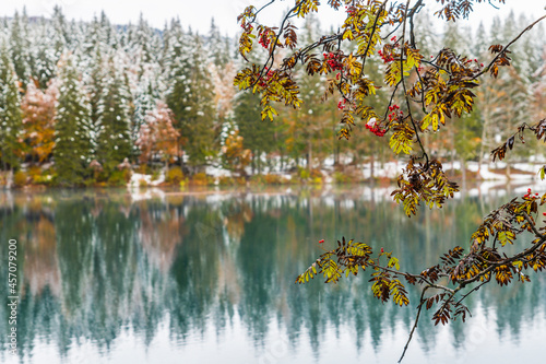 Between autumn and winter. Warm and cold reflections of snow on Lake Fusine.