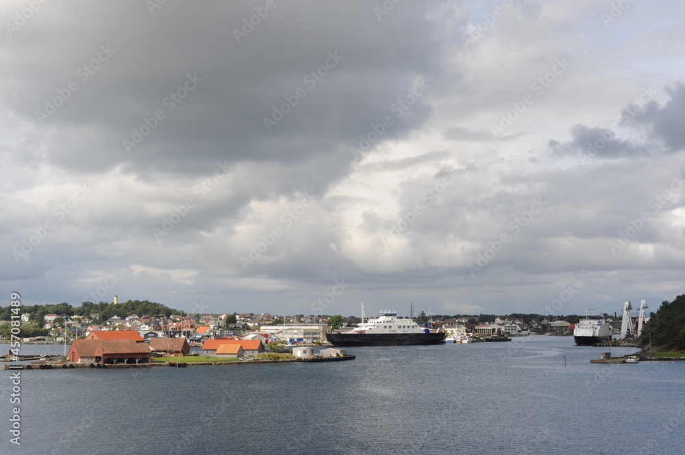Harbour in Stavanger, Norway on a cloudy day with a suspension bridge, boats and ferries in the North Sea