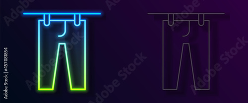 Glowing neon line Drying clothes icon isolated on black background. Clean pants. Wash clothes on a rope with clothespins. Clothing care and tidiness. Vector