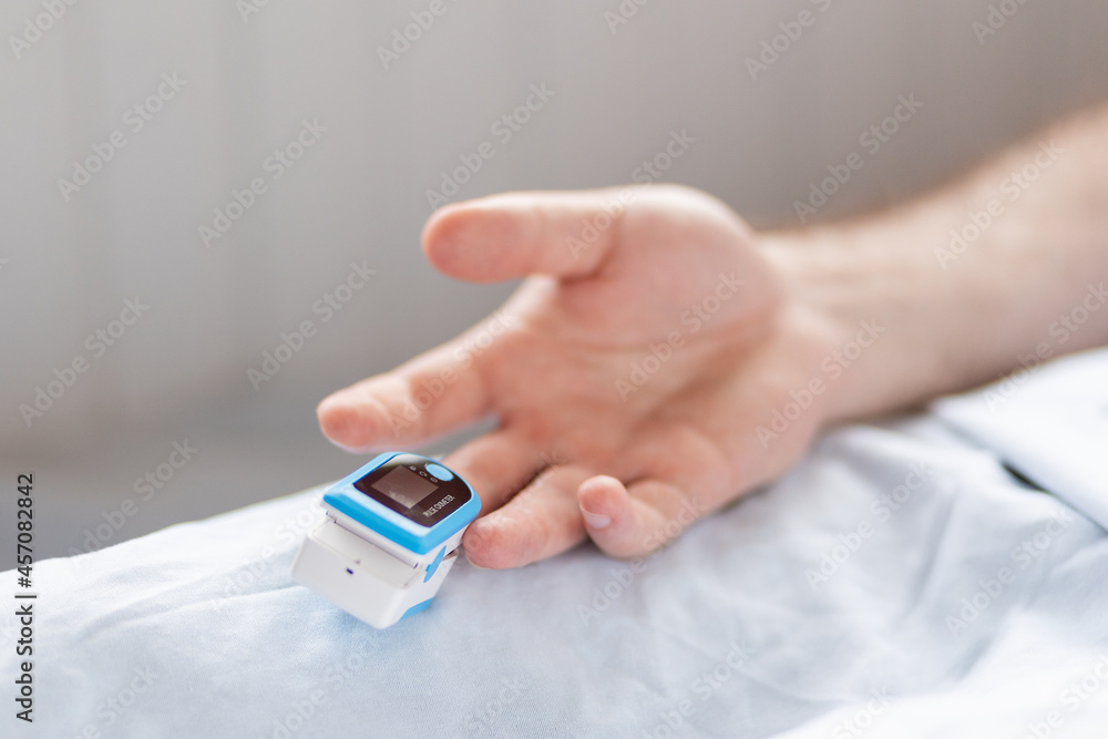 Determination of oxygen in the blood. Male hand with a pulse oximeter on the middle finger, close-up. Health care Determination of oxygen in the blood. Male hand with a pulse oximeter on the middle finger, close-up. Health care