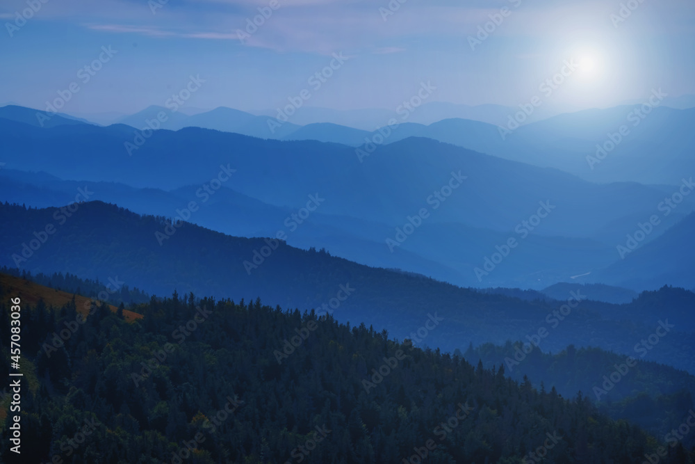 Obraz premium High peaks of beautiful dark blue mountain range landscape with fog and forest. Ukraine, Carpathians. Horizontal image.