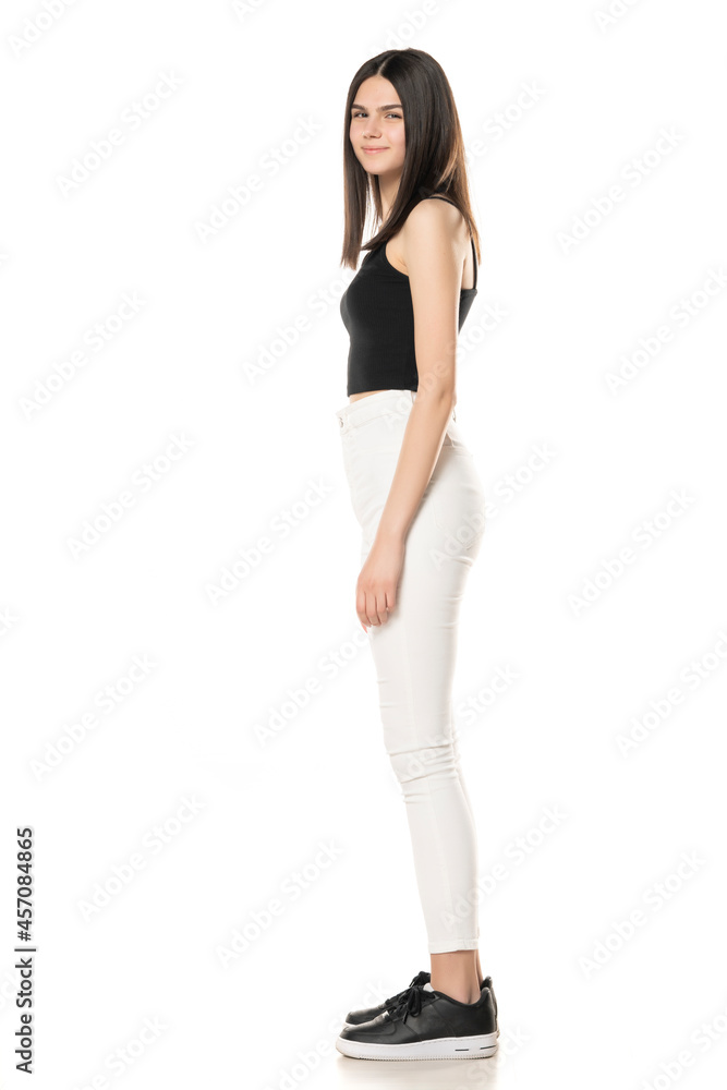 Side view of a teenage girl in white jeans and a black shirt Side view of a teenage girl in white jeans and a black shirt