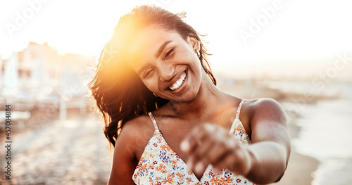 Portrait of a young black woman having fun at beach party - Happy female enjoying sunset by the sea - Beauty, positive and happy lifestyle concept 