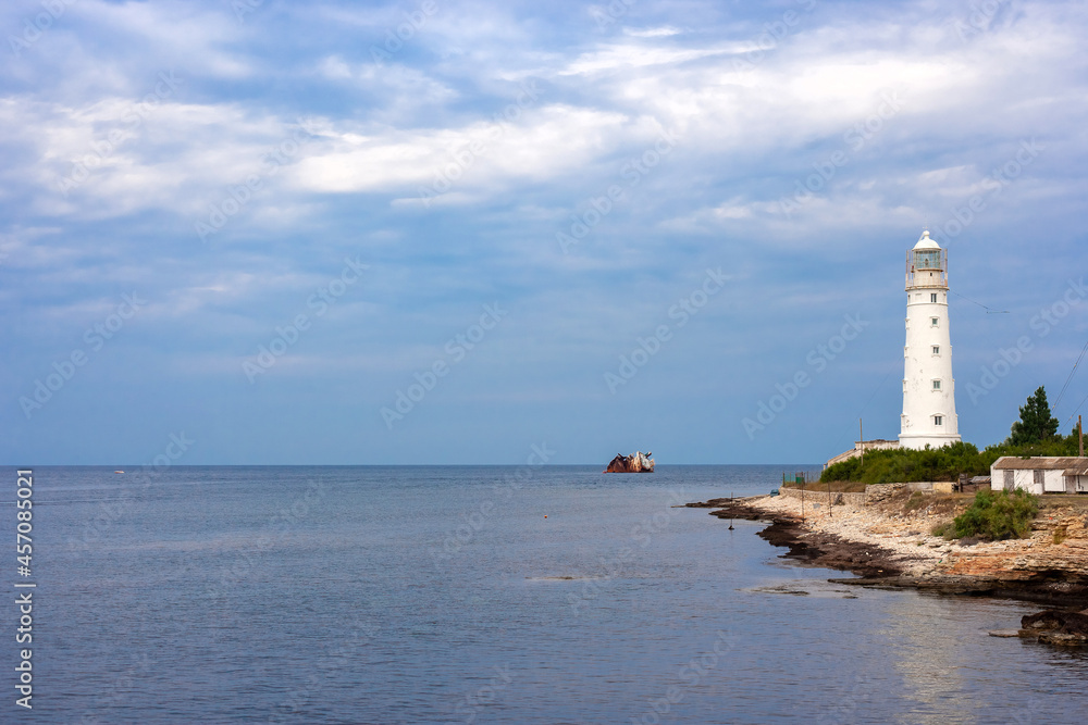 white lighthouse and the stranded cargo ship Ibrahim-yakim on the coast of Tarkhankut, Crimea
