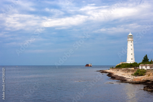 white lighthouse and the stranded cargo ship Ibrahim-yakim on the coast of Tarkhankut, Crimea