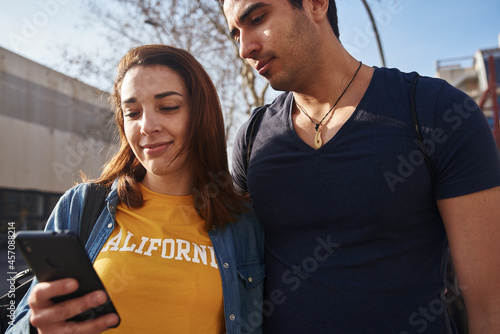 Young couple looking at a cell phone outdoors