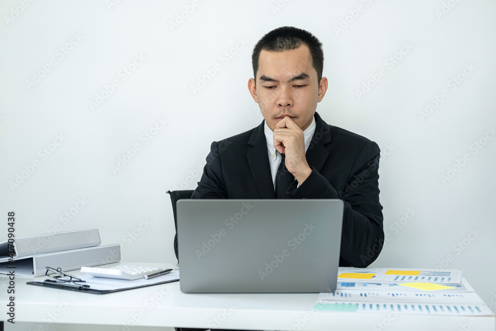 Businessman boss in suit is thinking and analysis of investments in new business from chart during to typing Businessman boss in suit is thinking and analysis of investments in new business from chart during to typing