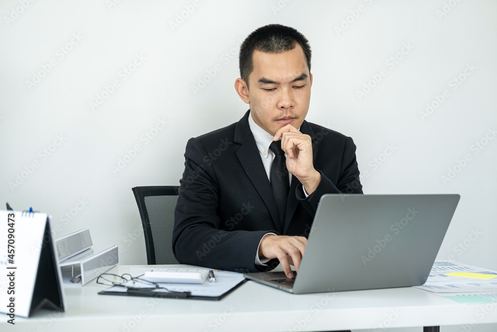 Businessman boss in suit is thinking and analysis of investments in new business from chart during to typing Businessman boss in suit is thinking and analysis of investments in new business from chart during to typing