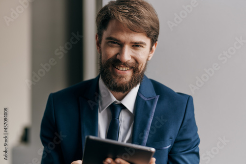bearded business man with tablet in hand communicating self-confidence
