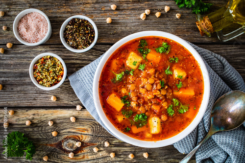 Delicious vege soup - boiled fresh vegetables and chickpeas on wooden table 