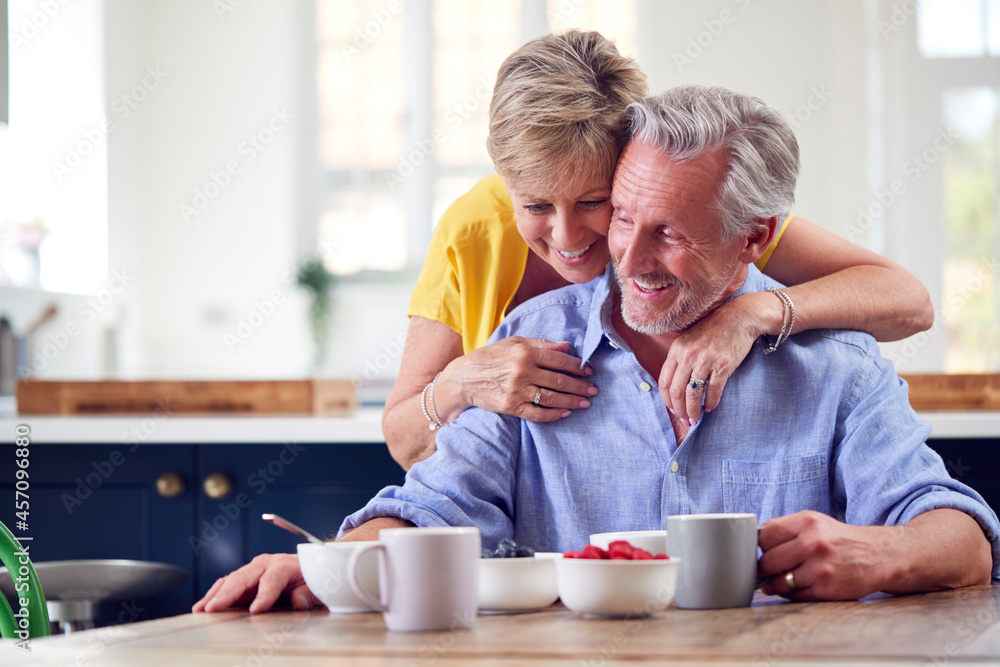 Loving Retired Couple Sitting Around Table At Home Having Healthy Breakfast Together Loving Retired Couple Sitting Around Table At Home Having Healthy Breakfast Together