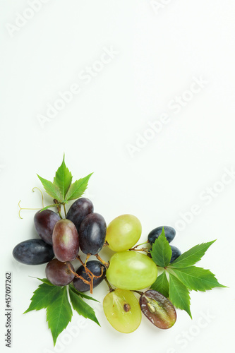 Ripe grape with leaves on white background