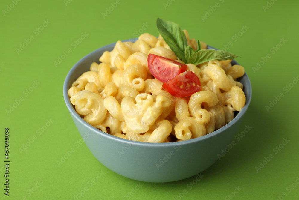 Plate with macaroni and cheese on green background Plate with macaroni and cheese on green background