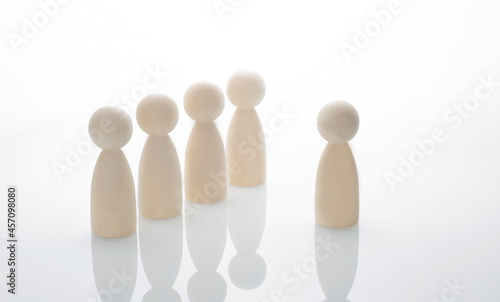 Wooden human figures on the white background. Leader concept