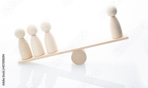 Wooden figure balancing on seesaw, leadership concept