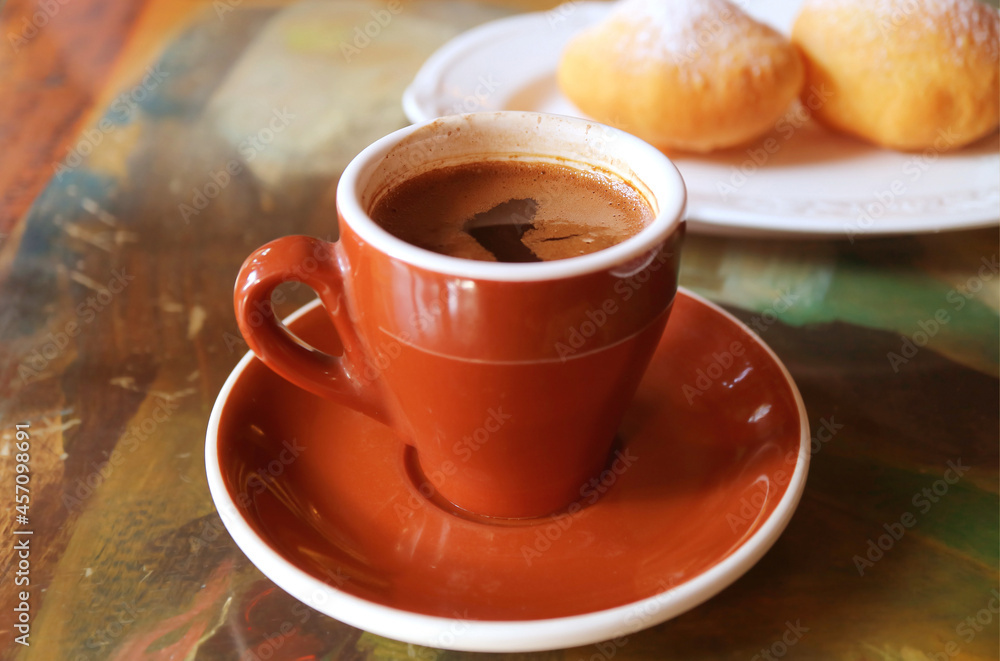 Cup of Hot Coffee with Blurry Fried Georgian Doughnuts in the Backdrop Cup of Hot Coffee with Blurry Fried Georgian Doughnuts in the Backdrop
