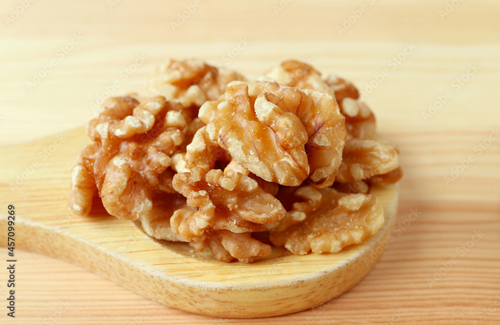 Pie of Walnut Kernels on a Wooden Spoon Isolated on Wooden Table