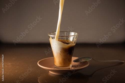 Obraz na plátně chorro de leche cae desde arriba entrando dentro de la taza de café para hacer c