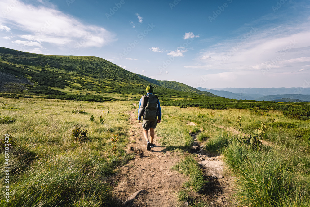 Obraz premium mountain tourism concept. hiking in the mountains. tourist with a backpack on his shoulders traveling. summer vacation