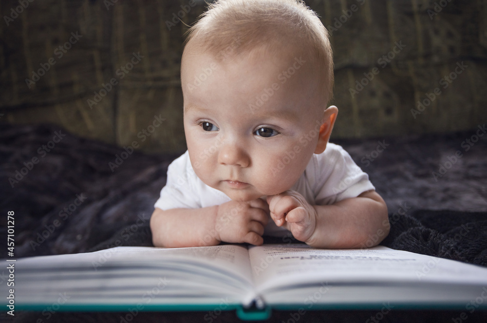 concept of education and development of children. babies are developed. baby reading a book. creative photography. concept of education and development of children. babies are developed. baby reading a book. creative photography.