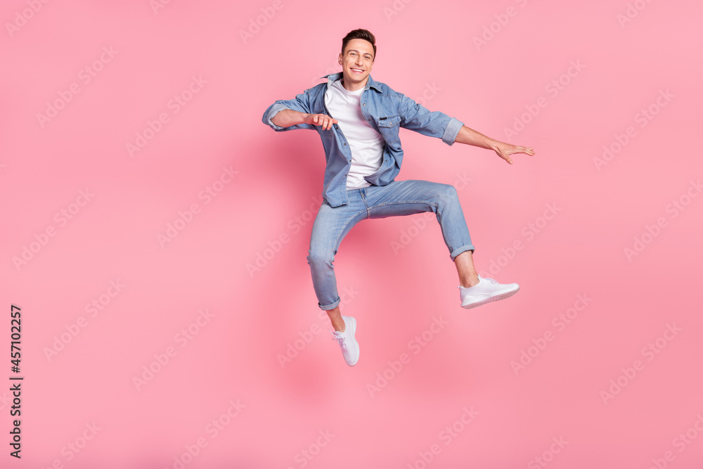 Full size photo of young good looking smiling cheerful guy jumping freedom summertime isolated on pink color background