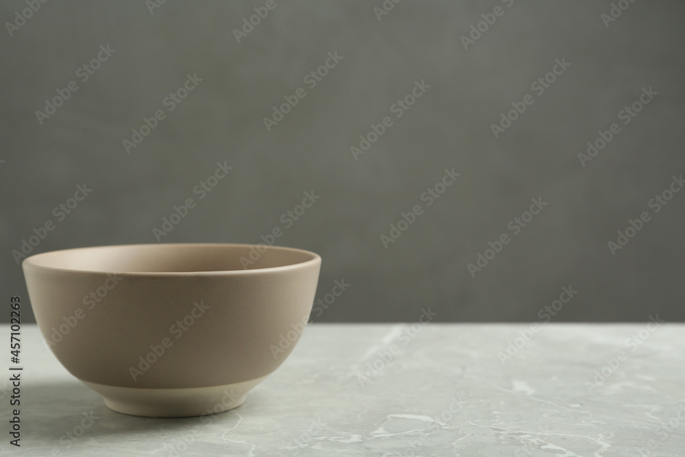 Stylish empty ceramic bowl on grey table, space for text. Cooking utensil Stylish empty ceramic bowl on grey table, space for text. Cooking utensil