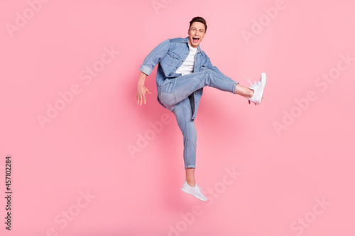 Full size photo of young smiling good mood male jumping dancing in air careless isolated on pink color background