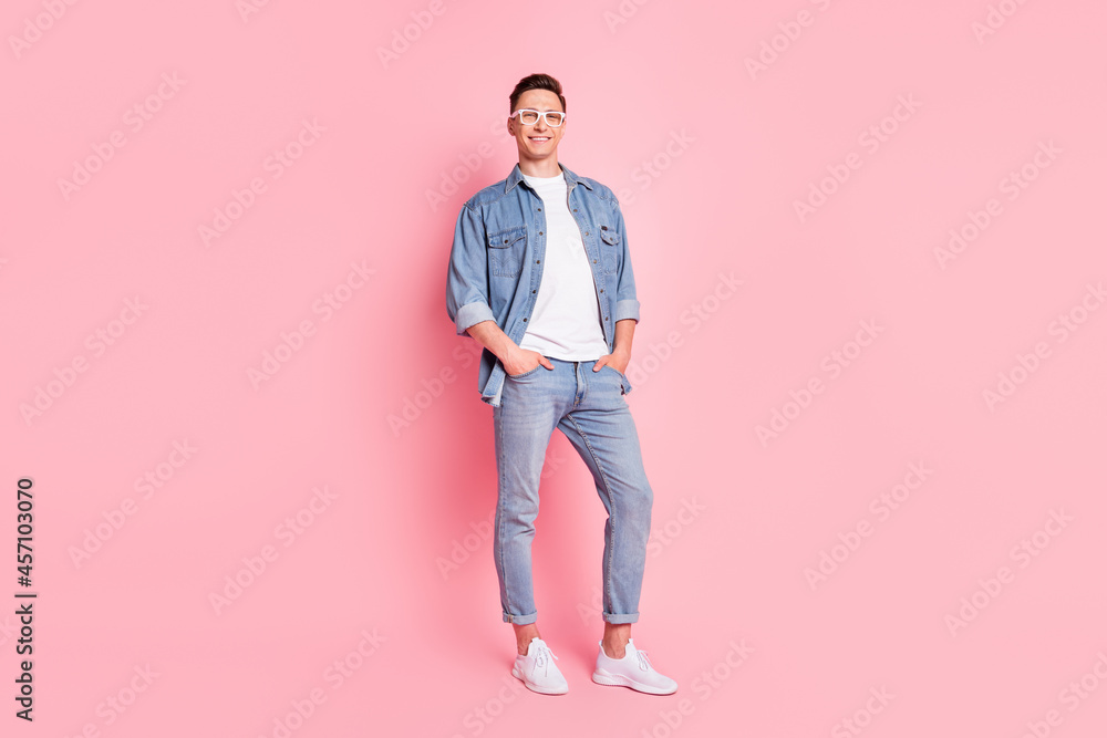 Full size photo of cool confident smiling cheerful male hold hands pockets wear spectacles isolated on pink color background Full size photo of cool confident smiling cheerful male hold hands pockets wear spectacles isolated on pink color background