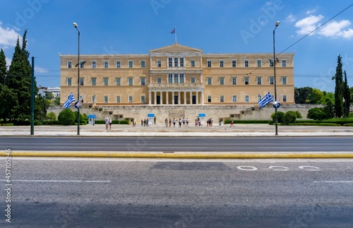 Greek Parliament in Athens, with the Greek flag blowing in the wind, on a sunny day