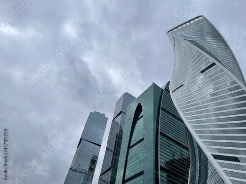 Facade of modern skyscraper with glass walls. From below of contemporary tall skyscraper with glass walls against cloudy sky in downtown