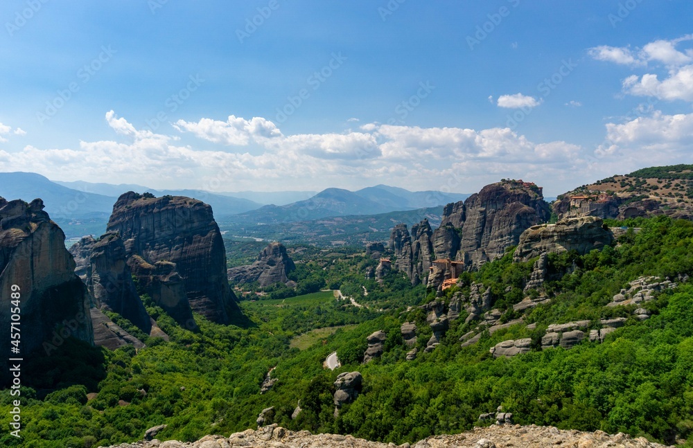 Panoramic view of Meteora with blue sky full of clouds and green forest