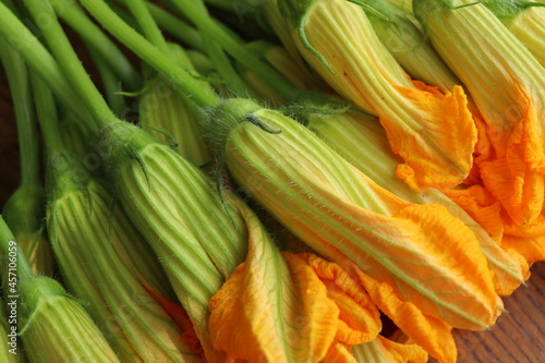 Fresh zucchini flowers on dark rustic background