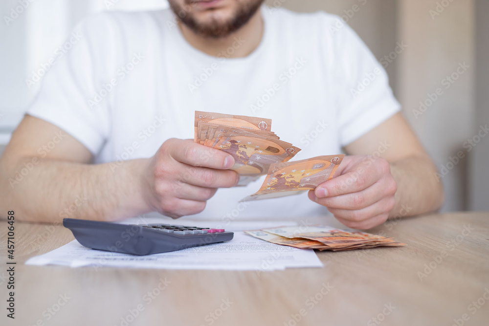 Man doing his accounting, financial adviser working. Man using calculator and calculate bills receipt in home expenses payments costs with paper note. Man doing his accounting, financial adviser working. Man using calculator and calculate bills receipt in home expenses payments costs with paper note.