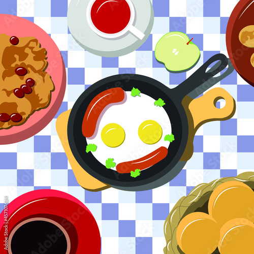 Fried eggs with sausages in a pan, buns with tea and fruits for breakfast