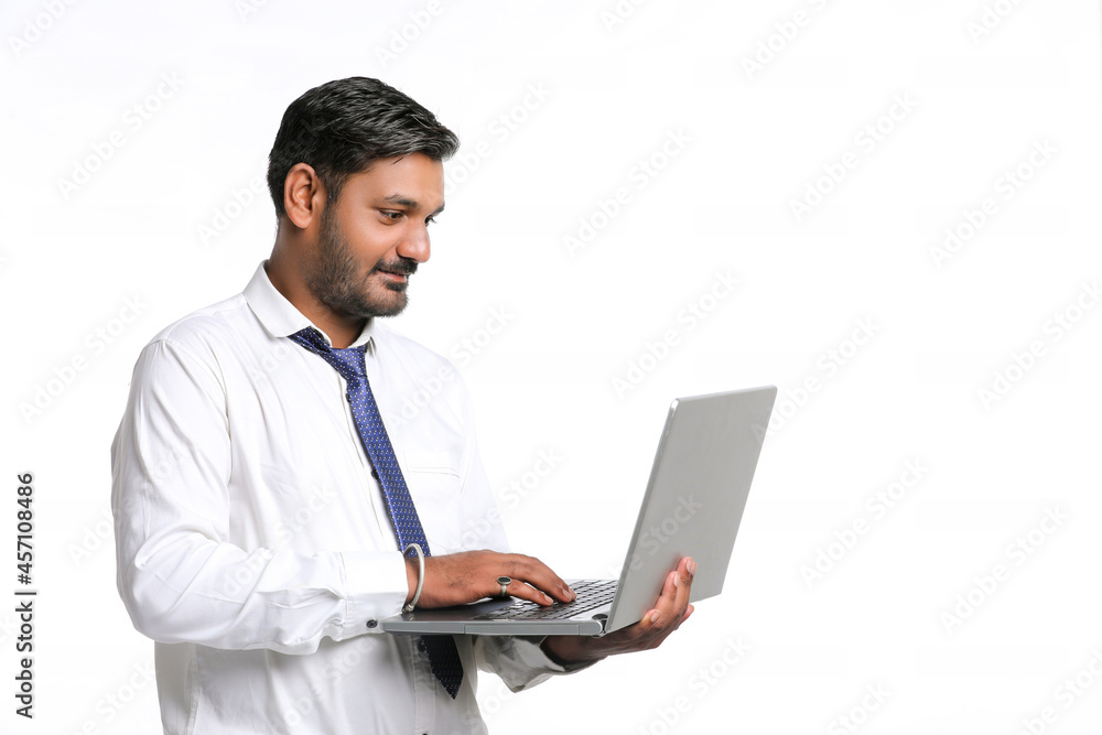 Young indian man using laptop on white background. Young indian man using laptop on white background.