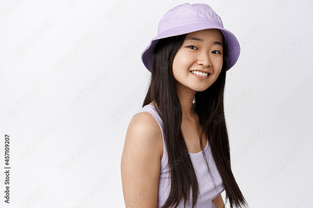 Close up portrait of brunette asian girl smiling, looking happy at camera, standing in stylish summer outfit against white background Close up portrait of brunette asian girl smiling, looking happy at camera, standing in stylish summer outfit against white background