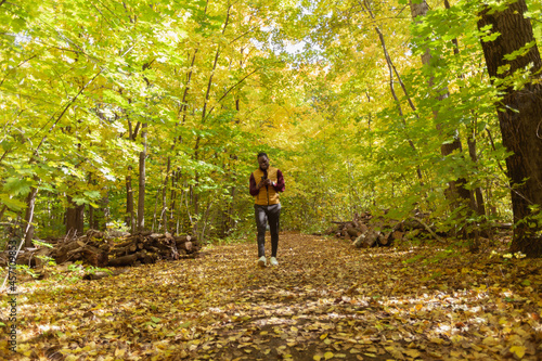 African american student walking in the park in autumn season